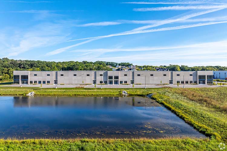 Panoramic view of Highlands Business Park with water feature and industrial building.